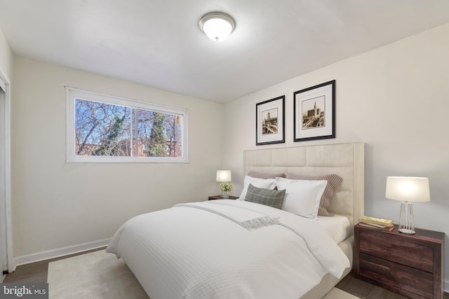 bedroom with baseboards and wood finished floors