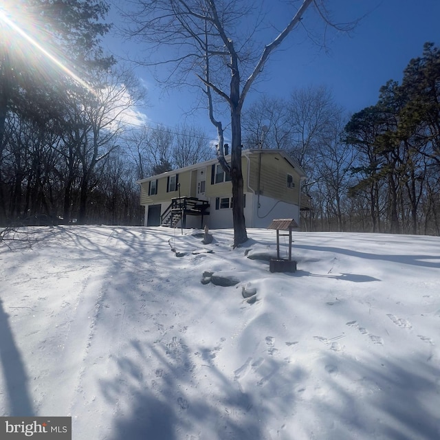 yard layered in snow featuring a garage