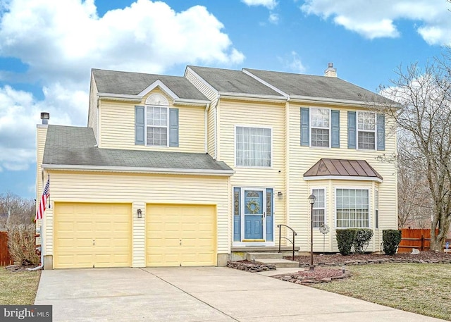 view of front facade featuring a garage, driveway, a chimney, and fence