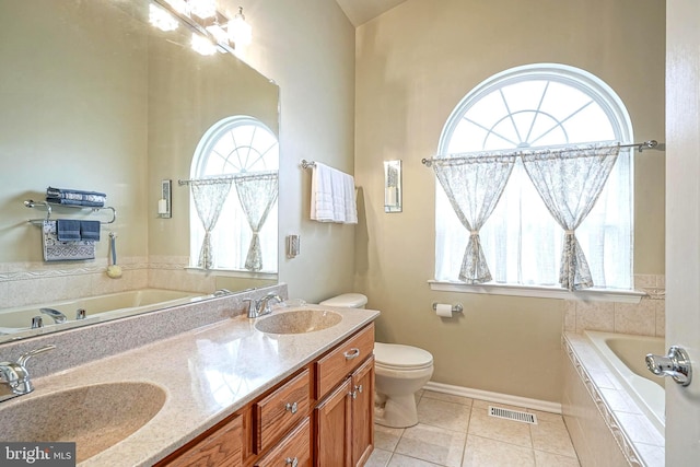 full bath featuring a garden tub, a sink, visible vents, and tile patterned floors