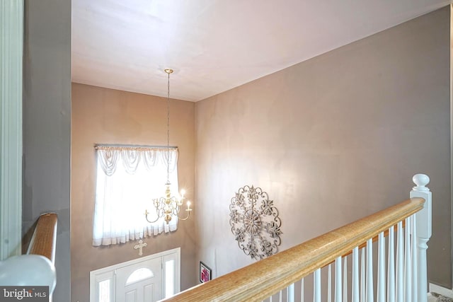 interior space with a notable chandelier and an upstairs landing