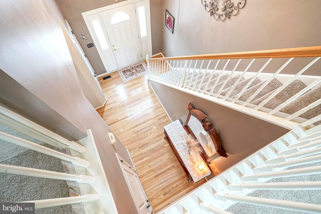 staircase with wood finished floors and visible vents