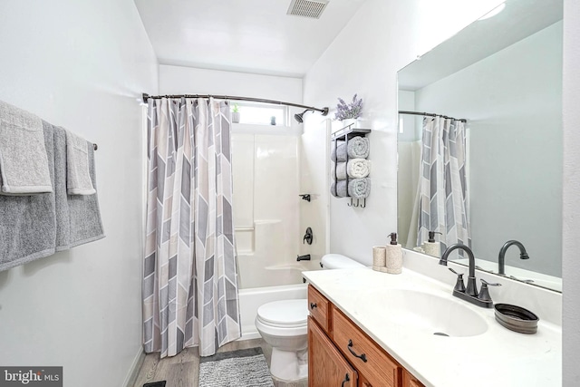 bathroom featuring visible vents, toilet, shower / tub combo, vanity, and wood finished floors