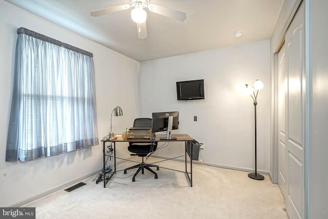 office with ceiling fan, baseboards, visible vents, and light colored carpet