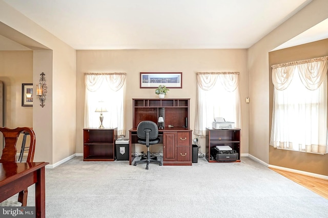 carpeted office space featuring baseboards