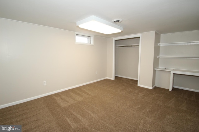 unfurnished bedroom featuring a closet, visible vents, dark carpet, and baseboards