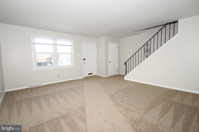 interior space with stairs, carpet floors, visible vents, and baseboards