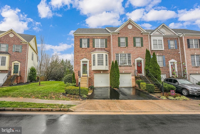 townhome / multi-family property with driveway, brick siding, stairway, an attached garage, and a front yard