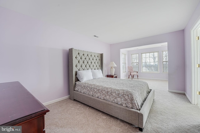 bedroom featuring light carpet, visible vents, and baseboards