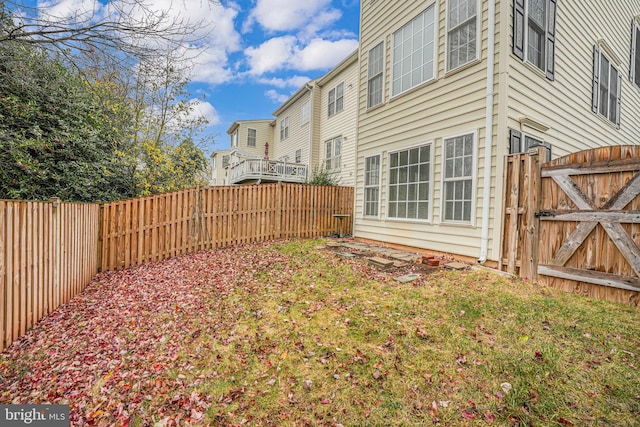 view of yard with a fenced backyard and a gate