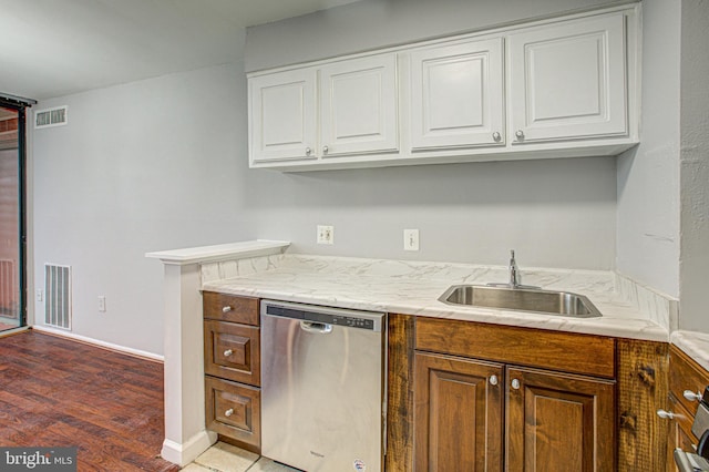 kitchen with light countertops, visible vents, white cabinetry, a sink, and dishwasher