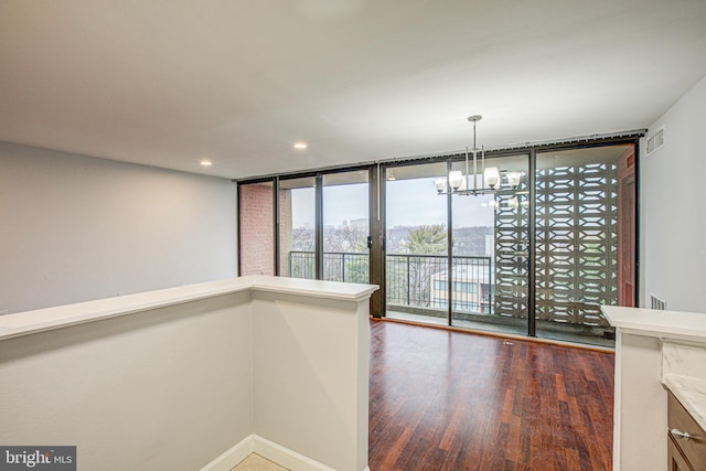 unfurnished dining area with visible vents, a chandelier, dark wood-style flooring, floor to ceiling windows, and recessed lighting