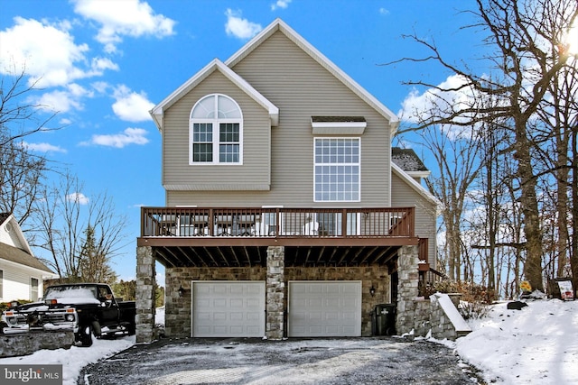 view of front facade featuring a garage, stone siding, and aphalt driveway