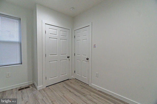 interior space featuring light wood finished floors, visible vents, and baseboards