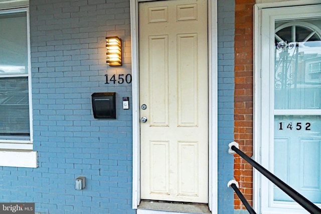 property entrance featuring brick siding