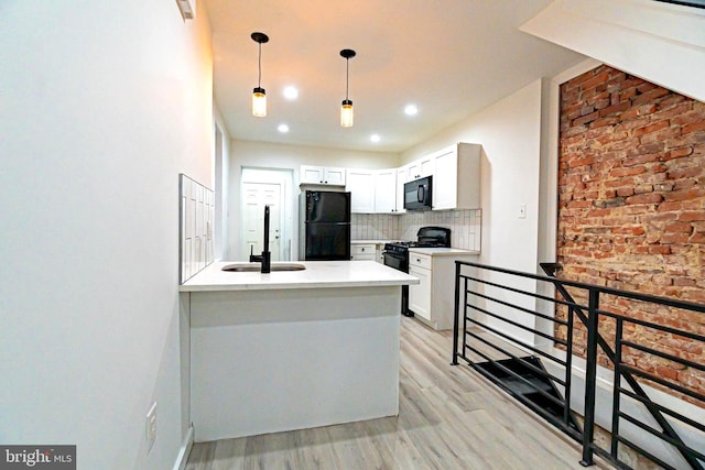 kitchen featuring a sink, white cabinets, light countertops, black appliances, and tasteful backsplash