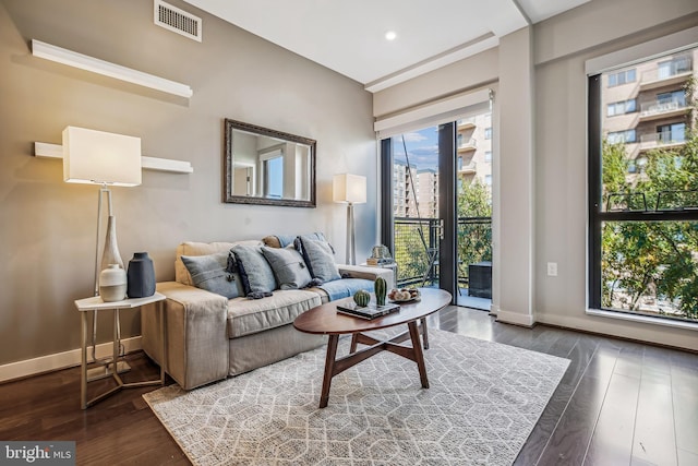 living room with recessed lighting, dark wood-style flooring, visible vents, and baseboards