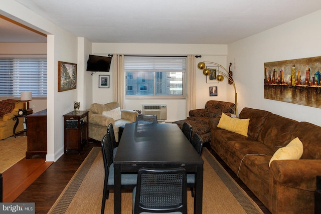 living area with dark wood-style floors and an AC wall unit