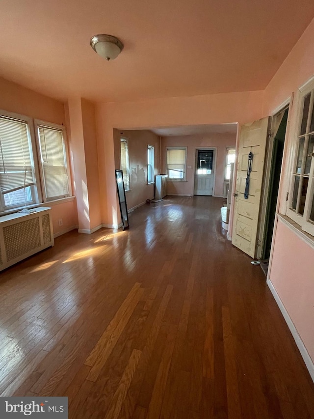 interior space with baseboards, dark wood-style flooring, and radiator