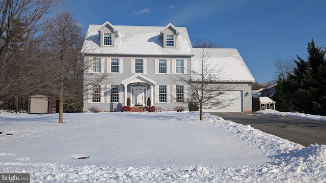 view of front of home featuring a garage, a storage unit, aphalt driveway, and an outbuilding