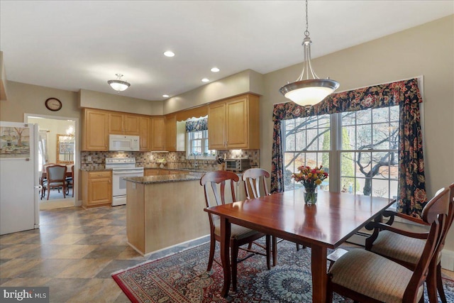 dining area featuring stone finish flooring, a toaster, and recessed lighting