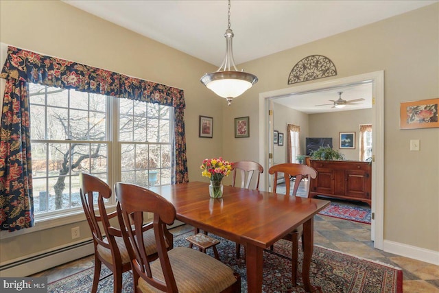 dining space with plenty of natural light, a baseboard heating unit, and baseboards