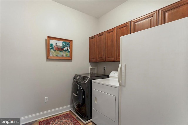 laundry room featuring cabinet space, independent washer and dryer, and baseboards