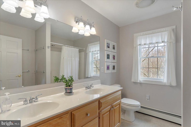 bathroom featuring double vanity, a baseboard radiator, toilet, and a sink