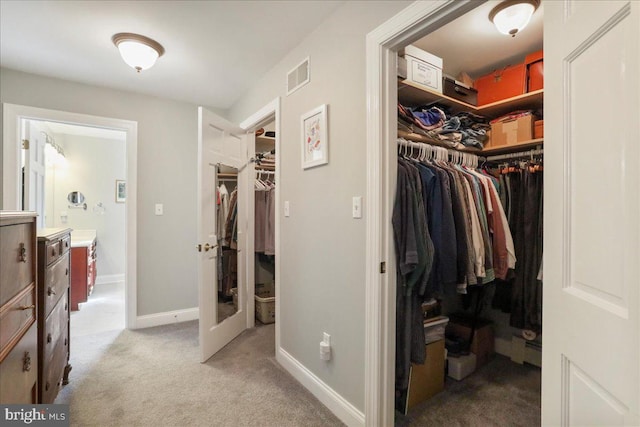 spacious closet featuring visible vents and light carpet