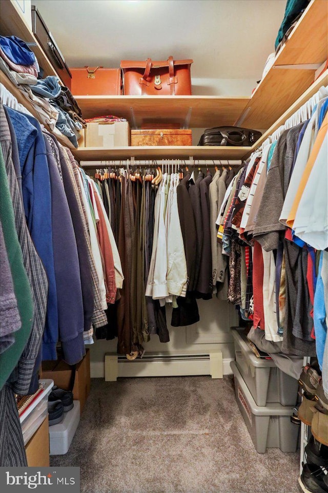 walk in closet with a baseboard heating unit and carpet flooring