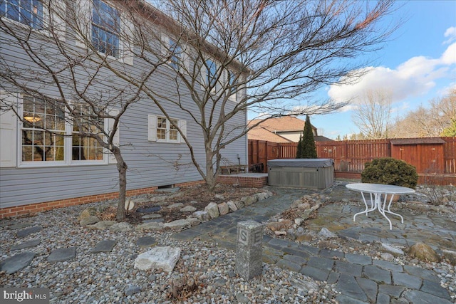 exterior space featuring fence, a hot tub, and a patio