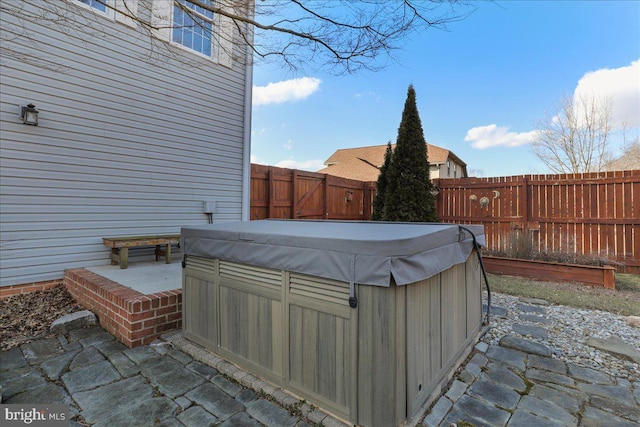 view of patio featuring a hot tub and a fenced backyard