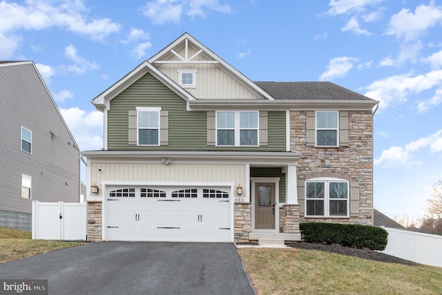 craftsman inspired home featuring a garage, fence, aphalt driveway, and board and batten siding