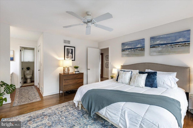 bedroom featuring visible vents, ensuite bathroom, a ceiling fan, wood finished floors, and baseboards