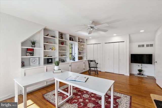 home office featuring visible vents, light wood-type flooring, a ceiling fan, and recessed lighting