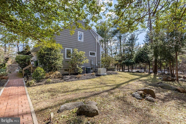 view of side of property with fence and central AC unit