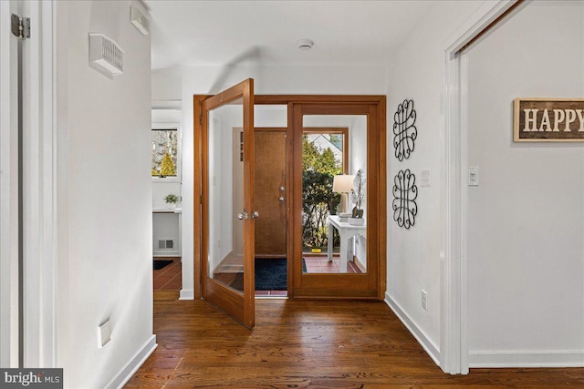 entrance foyer featuring baseboards, visible vents, and wood finished floors