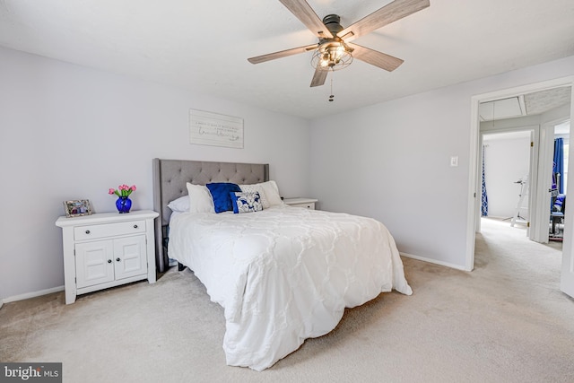 bedroom with light carpet, attic access, baseboards, and ceiling fan