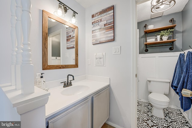 bathroom featuring vanity, toilet, and a textured ceiling