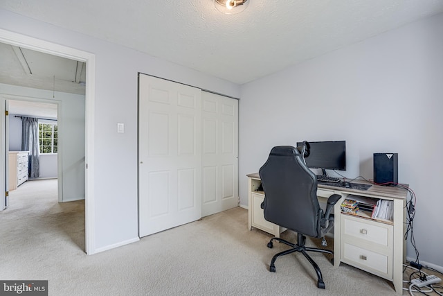 office space with light carpet, attic access, and baseboards