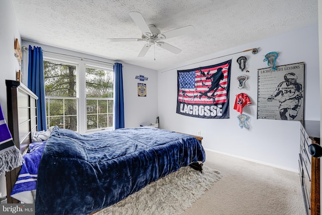 carpeted bedroom with ceiling fan, a textured ceiling, and baseboards