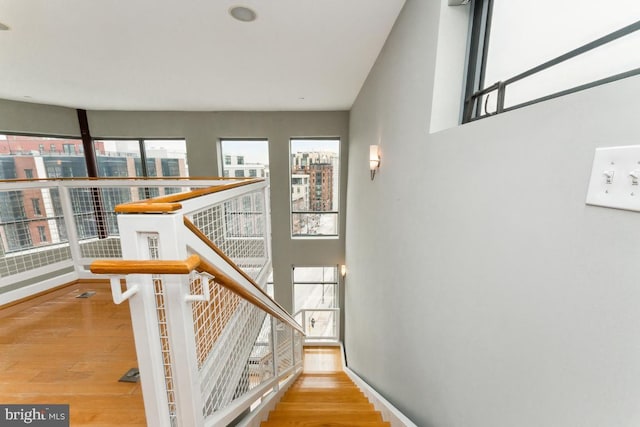 stairway featuring a view of city, baseboards, and wood finished floors