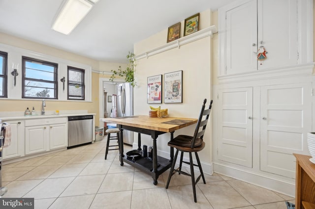 dining space featuring light tile patterned floors and baseboards