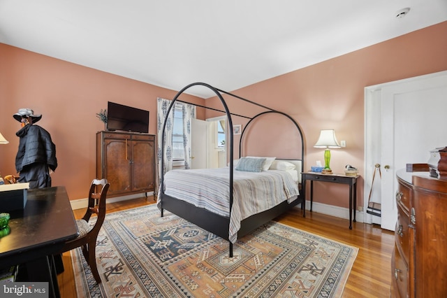 bedroom with light wood-type flooring and baseboards