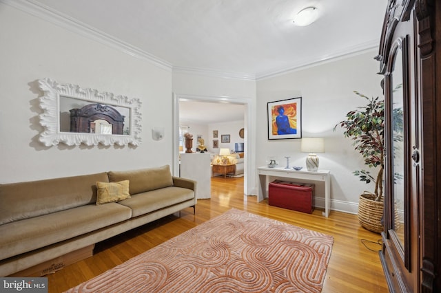 living area with baseboards, ornamental molding, and wood finished floors