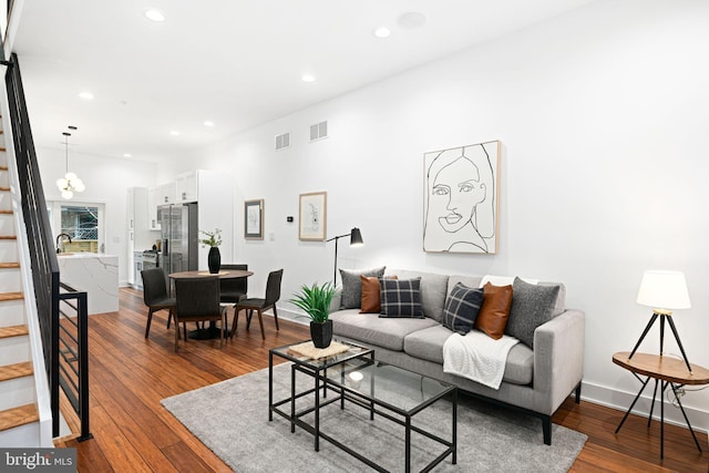 living room with dark wood-type flooring, stairway, visible vents, and recessed lighting