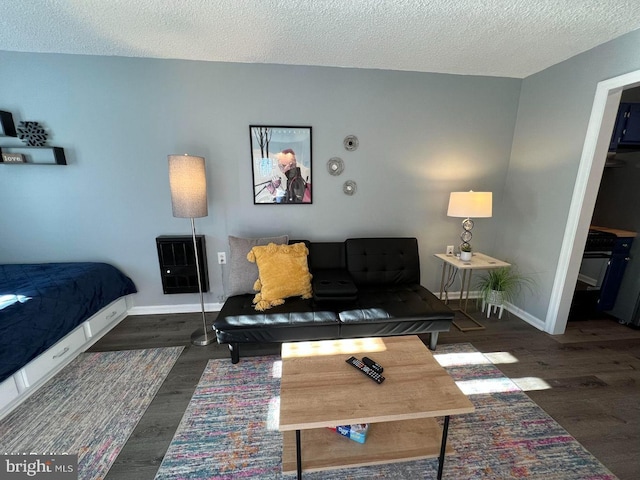 living area featuring a textured ceiling, baseboards, and dark wood-type flooring