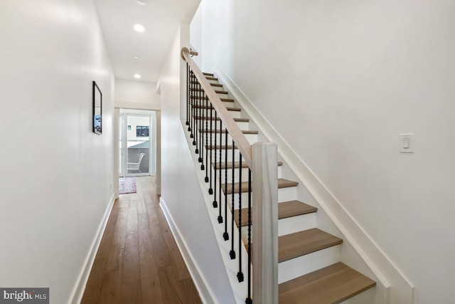 staircase with recessed lighting, baseboards, and wood finished floors