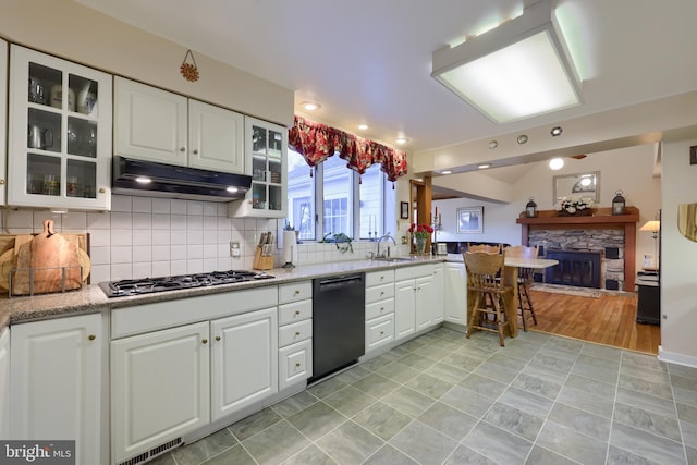 kitchen featuring black dishwasher, white cabinetry, a sink, and under cabinet range hood