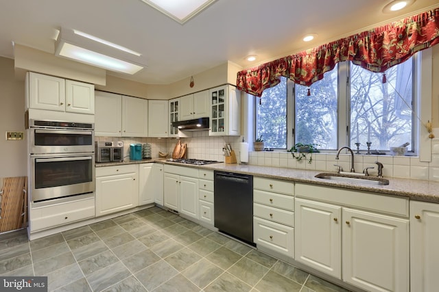 kitchen with white cabinets, glass insert cabinets, stainless steel appliances, and a sink